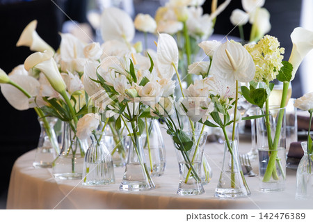 Table arrangement featuring a collection of white flowers Table arrangement featuring a collection of white flowers 142476389