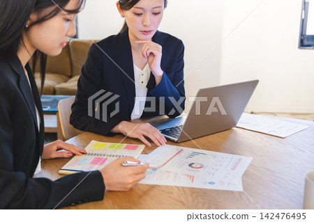 工作在辦公室的一個年輕商人 工作在辦公室的一個年輕商人 142476495