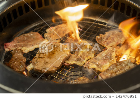 Beef Slices Grilling over Open Flames on Charcoal Grill Beef Slices Grilling over Open Flames on Charcoal Grill 142476951