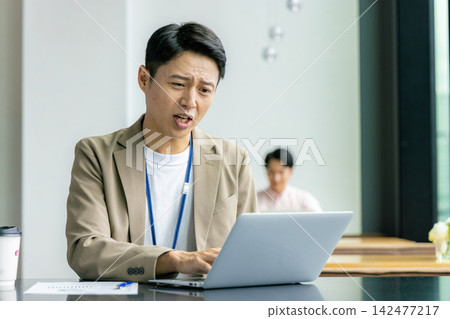 An agonizing businessman An agonizing businessman 142477217