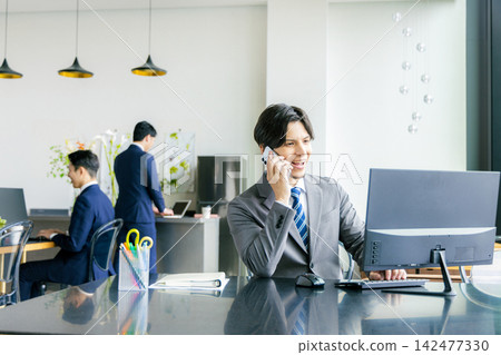 A businessman calling in the office A businessman calling in the office 142477330