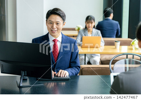 A businessman heading to a computer in the office A businessman heading to a computer in the office 142477467