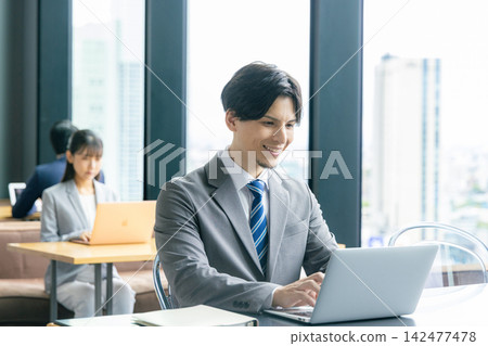 Young businessman doing desk work Young businessman doing desk work 142477478