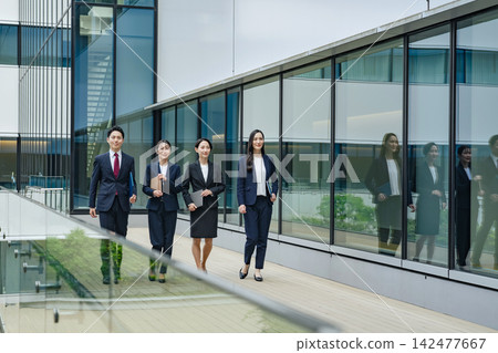 A group of business people walking down the street. Teamwork, colleagues, progress, advancement, start, goal, challenge. A group of business people walking down the street. Teamwork, colleagues, progress, advancement, start, goal, challenge. 142477667