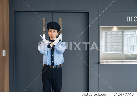 保安人員在入口處攔住行人。保全、預防犯罪、禁止入內、警告、違規、規則、公司、設施、接待處。 保安人員在入口處攔住行人。保全、預防犯罪、禁止入內、警告、違規、規則、公司、設施、接待處。 142477746
