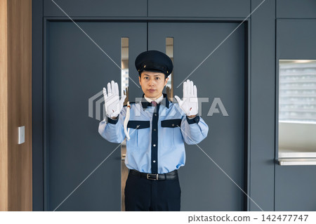 保安人員在入口處攔住行人。保全、預防犯罪、禁止入內、警告、違規、規則、公司、設施、接待處。 142477747
