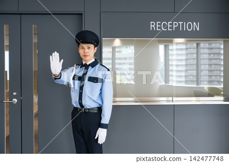 A security guard stops people at the entrance. Security, crime prevention, no entry, warning, violation, rules, company, facility, reception. A security guard stops people at the entrance. Security, crime prevention, no entry, warning, violation, rules, company, facility, reception. 142477748