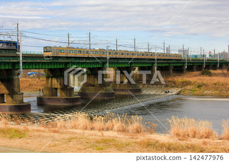 A JR Nambu Line 205 series train crosses the Tamagawa River, with the railway bridge and the surrounding natural scenery (Kawasaki City). A JR Nambu Line 205 series train crosses the Tamagawa River, with the railway bridge and the surrounding natural scenery (Kawasaki City). 142477976