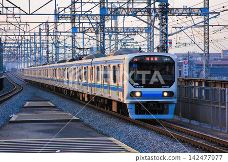 A Tokyo Waterfront Area Rapid Transit 70-000 series train running on the Saikyo Line, illuminated by the setting sun (Saitama Prefecture). 142477977