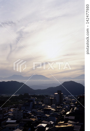 夕陽西下,湯田中溫泉的城鎮景色被照亮,群山從雲層後探出頭來,從高處俯瞰,呈現出垂直落日的壯麗景象(長野縣山之內町) 夕陽西下,湯田中溫泉的城鎮景色被照亮,群山從雲層後探出頭來,從高處俯瞰,呈現出垂直落日的壯麗景象(長野縣山之內町) 142477980