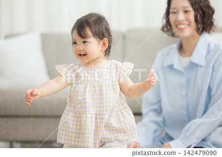 A 1-year-old girl and her mother in the living room A 1-year-old girl and her mother in the living room 142479090