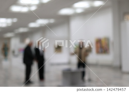 A group stands in an art gallery. 142479457