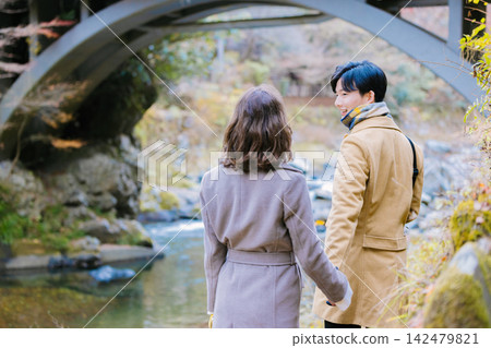 一對情侶從背後欣賞著秋日美景。 一對情侶從背後欣賞著秋日美景。 142479821