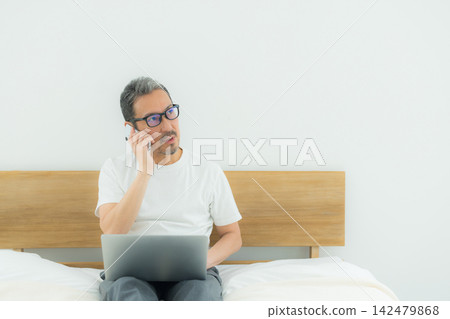 一個人在床上看電腦 一個人在床上看電腦 142479868