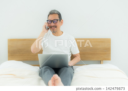 一個人在床上看電腦 一個人在床上看電腦 142479873