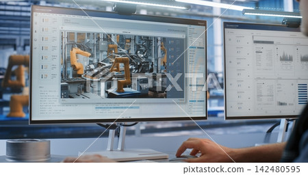 Engineer Supervising Live Robotic Arm Welding Stream on Monitor in Smart Factory Engineer Supervising Live Robotic Arm Welding Stream on Monitor in Smart Factory 142480595