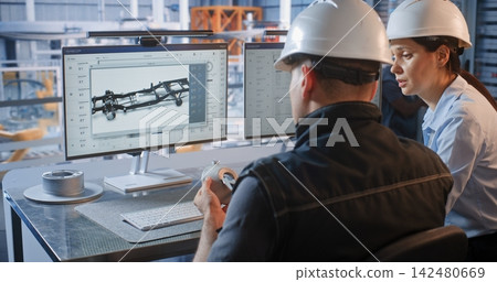 Engineers Discussing 3D Car Chassis CAD Model at Smart Factory Desk Engineers Discussing 3D Car Chassis CAD Model at Smart Factory Desk 142480669
