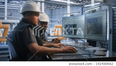 Industrial Team Analyzing Smart Factory Telemetry on Dual Monitors Industrial Team Analyzing Smart Factory Telemetry on Dual Monitors 142480682