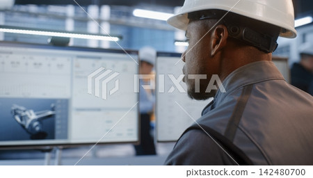 Industrial Specialist Verifying Automotive Structural Data on PC Industrial Specialist Verifying Automotive Structural Data on PC 142480700