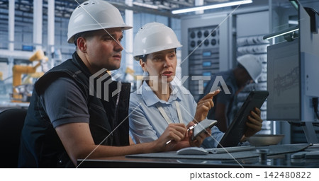 Engineers Discussing Component Measurements and CAD Specs in Factory Engineers Discussing Component Measurements and CAD Specs in Factory 142480822