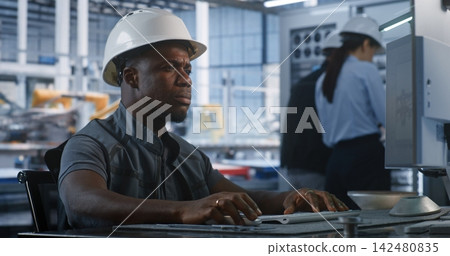 Engineer Monitoring Smart Factory Data at Workstation Engineer Monitoring Smart Factory Data at Workstation 142480835