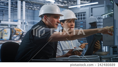Engineers Discussing Component Measurements and CAD Specs in Factory Engineers Discussing Component Measurements and CAD Specs in Factory 142480889