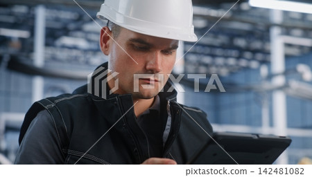 Technician Auditing Automated Production Line via Mobile Tablet 142481082