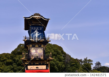日本愛知縣犬山祭:雄偉的犬山城天守閣和聚集在城堡廣場前的花車,這是機械木偶獻祭前的場景。 日本愛知縣犬山祭:雄偉的犬山城天守閣和聚集在城堡廣場前的花車,這是機械木偶獻祭前的場景。 142481571