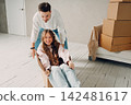 Happy young family couple man carry woman inside box. Moving with cardboard boxes to new estate home apartment concept. 142481617