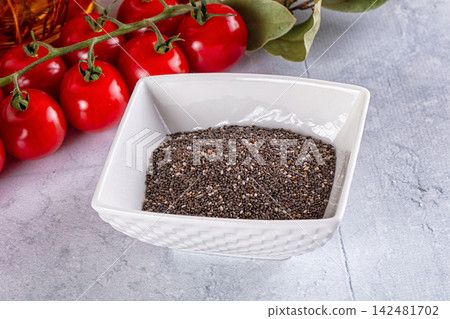 Chia seeds in white bowl with fresh cherry tomatoes and bay leaves on gray background Chia seeds in white bowl with fresh cherry tomatoes and bay leaves on gray background 142481702