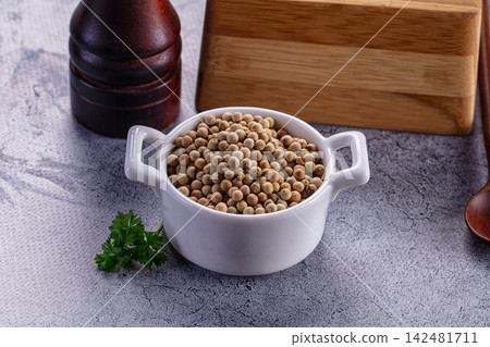 White peppercorns in ceramic bowl with wooden mill and fresh parsley on grey background White peppercorns in ceramic bowl with wooden mill and fresh parsley on grey background 142481711
