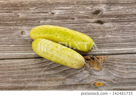 Two ripe yellow cucumbers on rustic wooden background Two ripe yellow cucumbers on rustic wooden background 142481735