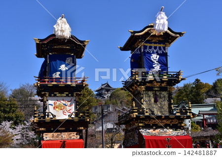 Inuyama Festival in Aichi Prefecture: Inuyama Castle's keep, the floats gathered in front of the castle plaza, and cherry blossoms in full bloom; a scene before the dedication of the mechanical puppets. Inuyama Festival in Aichi Prefecture: Inuyama Castle's keep, the floats gathered in front of the castle plaza, and cherry blossoms in full bloom; a scene before the dedication of the mechanical puppets. 142481887