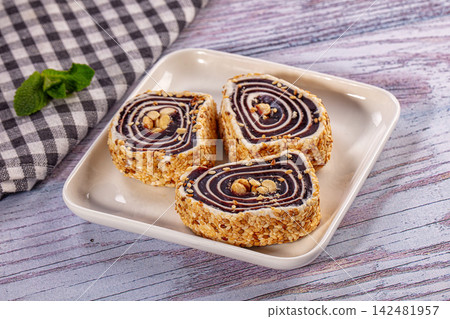 Turkish delight rolls with peanuts and sesame seeds on ceramic plate 142481957