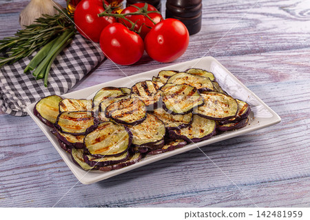 Grilled eggplant slices on white plate with fresh tomatoes and herbs Grilled eggplant slices on white plate with fresh tomatoes and herbs 142481959