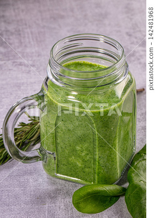 Healthy green detox smoothie with fresh spinach and rosemary in glass mason jar on grey background Healthy green detox smoothie with fresh spinach and rosemary in glass mason jar on grey background 142481968