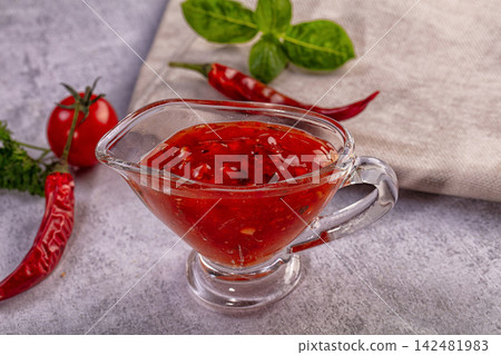 Spicy tomato chili sauce in glass boat with fresh ingredients Spicy tomato chili sauce in glass boat with fresh ingredients 142481983