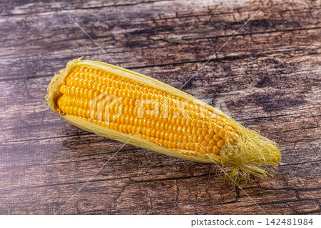 Fresh corn on the cob with husk on rustic wooden table Fresh corn on the cob with husk on rustic wooden table 142481984