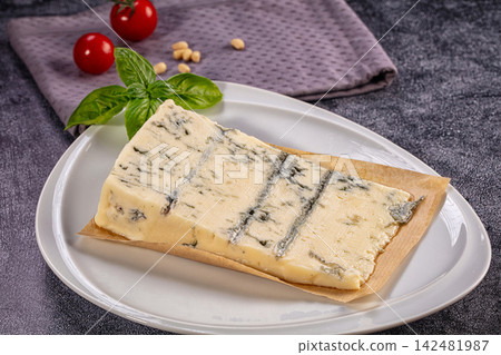 Gorgonzola cheese wedge on white plate with basil and tomatoes Gorgonzola cheese wedge on white plate with basil and tomatoes 142481987
