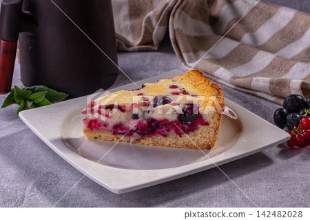 Slice of berry pie with blueberry and red currant on a white plate 142482028