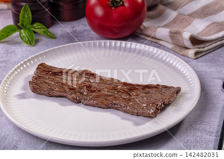 Grilled thin beef steak on white plate with fresh tomato and basil Grilled thin beef steak on white plate with fresh tomato and basil 142482031