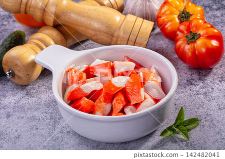 Chopped surimi sticks in white bowl with fresh vegetables and spices Chopped surimi sticks in white bowl with fresh vegetables and spices 142482041