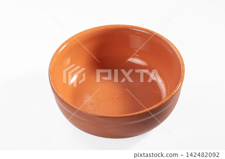 Empty terracotta bowl with glazed interior on white background Empty terracotta bowl with glazed interior on white background 142482092