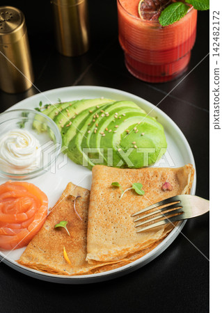 Roasted thin pancakes with smoked salmon and sauce Roasted thin pancakes with smoked salmon and sauce 142482172