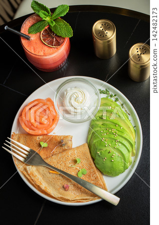 Roasted thin pancakes with smoked salmon and sauce Roasted thin pancakes with smoked salmon and sauce 142482173