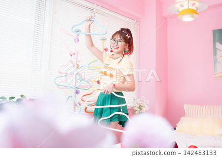 一個女孩在玩衣架 一個女孩在玩衣架 142483133