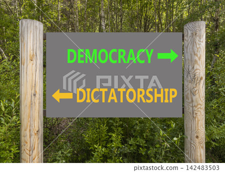 Democracy or dictatorship words symbol. Concept words Democracy Dictatorship on beautiful road sign. Beautiful green forest background. Business democracy dictatorship concept. Copy space Democracy or dictatorship words symbol. Concept words Democracy Dictatorship on beautiful road sign. Beautiful green forest background. Business democracy dictatorship concept. Copy space 142483503