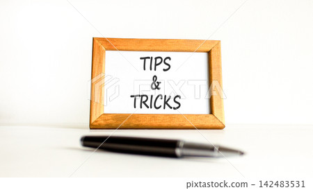 Tips and tricks words symbol. Concept words Tips and tricks on beautiful wooden picture frame. Beautiful white background. Business tips and tricks motivational support concept. Copy space. 142483531
