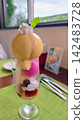 一份精美的桃子芭菲，上面放著一整個桃子。 142483728