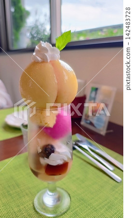 一份精美的桃子芭菲,上面放著一整個桃子。 一份精美的桃子芭菲,上面放著一整個桃子。 142483728